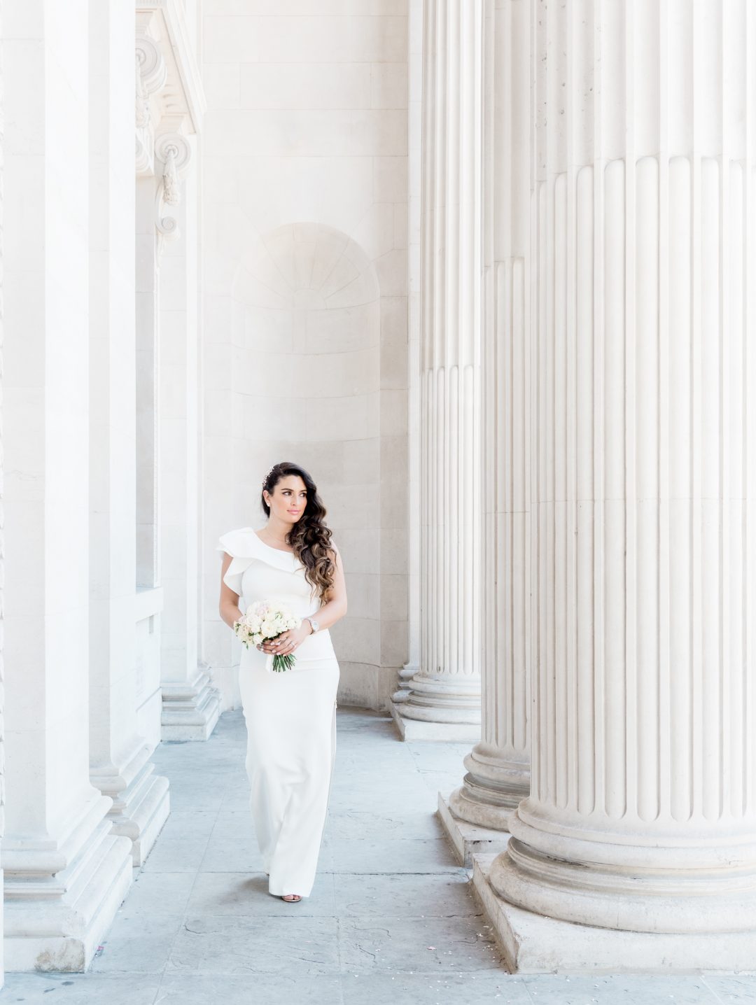 Bride walking between the columns at Old Marylebone Town Hall