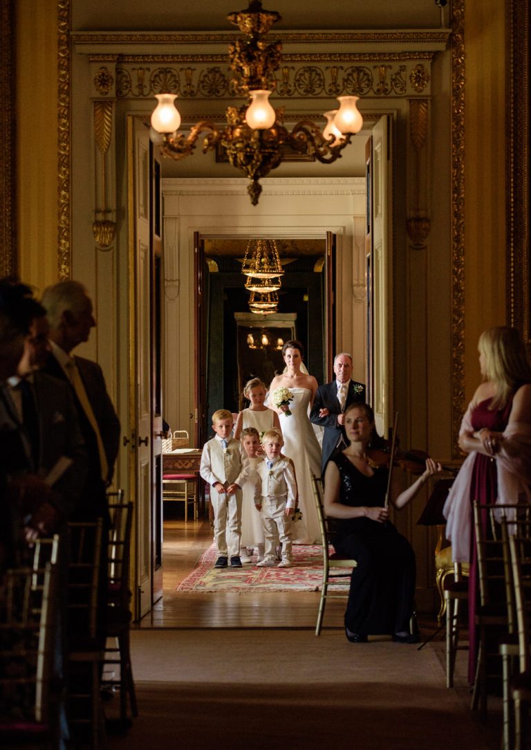 Bride walking in with her father for the ceremony at Goodwood House