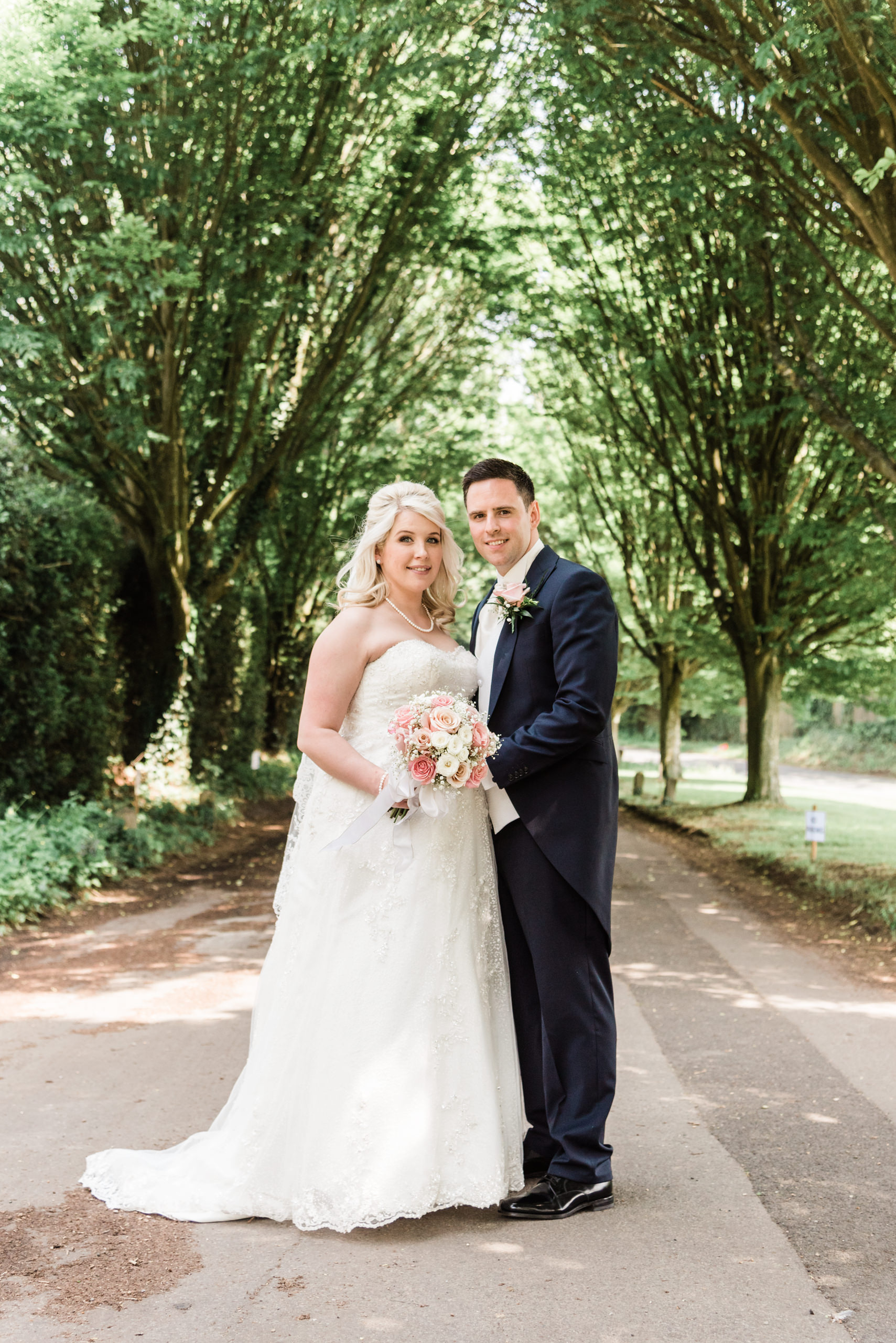 Bride and groom on a tree-lined path at their High Rocks wedding near Tunbridge Wells
