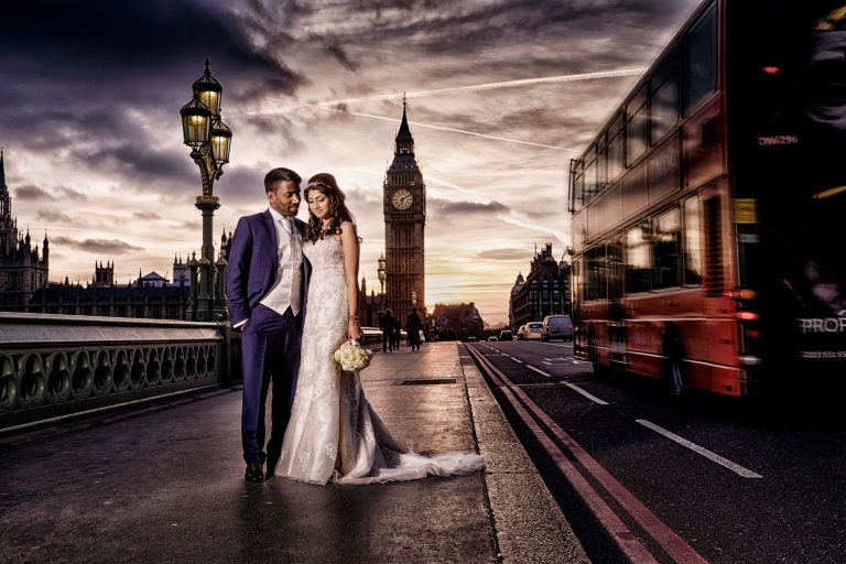 Pre wedding couple on Westminster Bridge at dusk with Big Ben and a red London bus