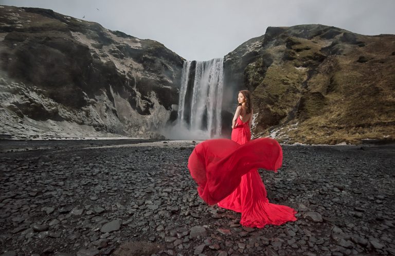 Bride in a red dress by a waterfall in Iceland