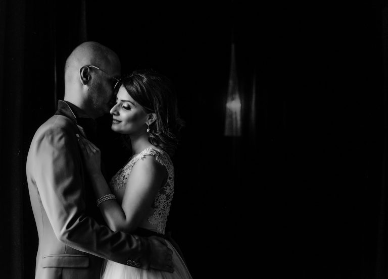 Bride and groom lit against a dark background at a London wedding