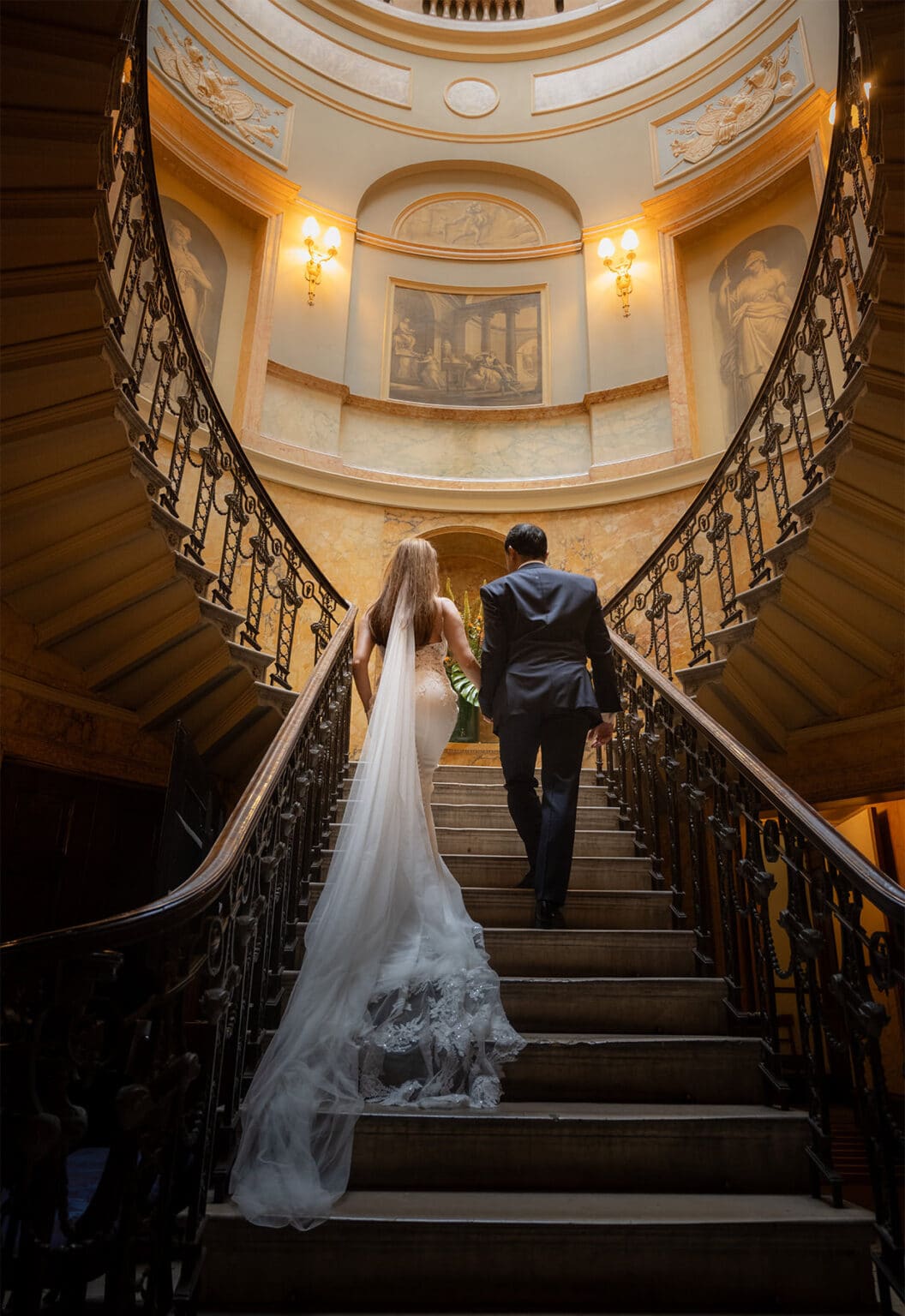Bride and groom on the grand staircase at Home House, London