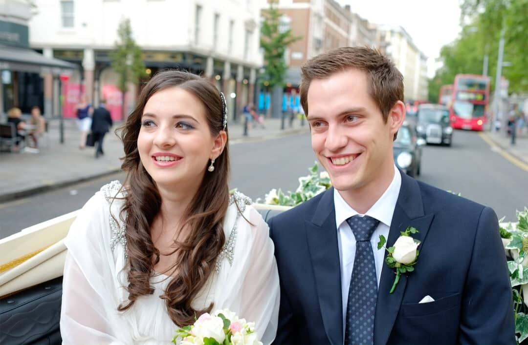 Liliya and Charles in an open carriage on the King's Road after their Chelsea Old Town Hall wedding