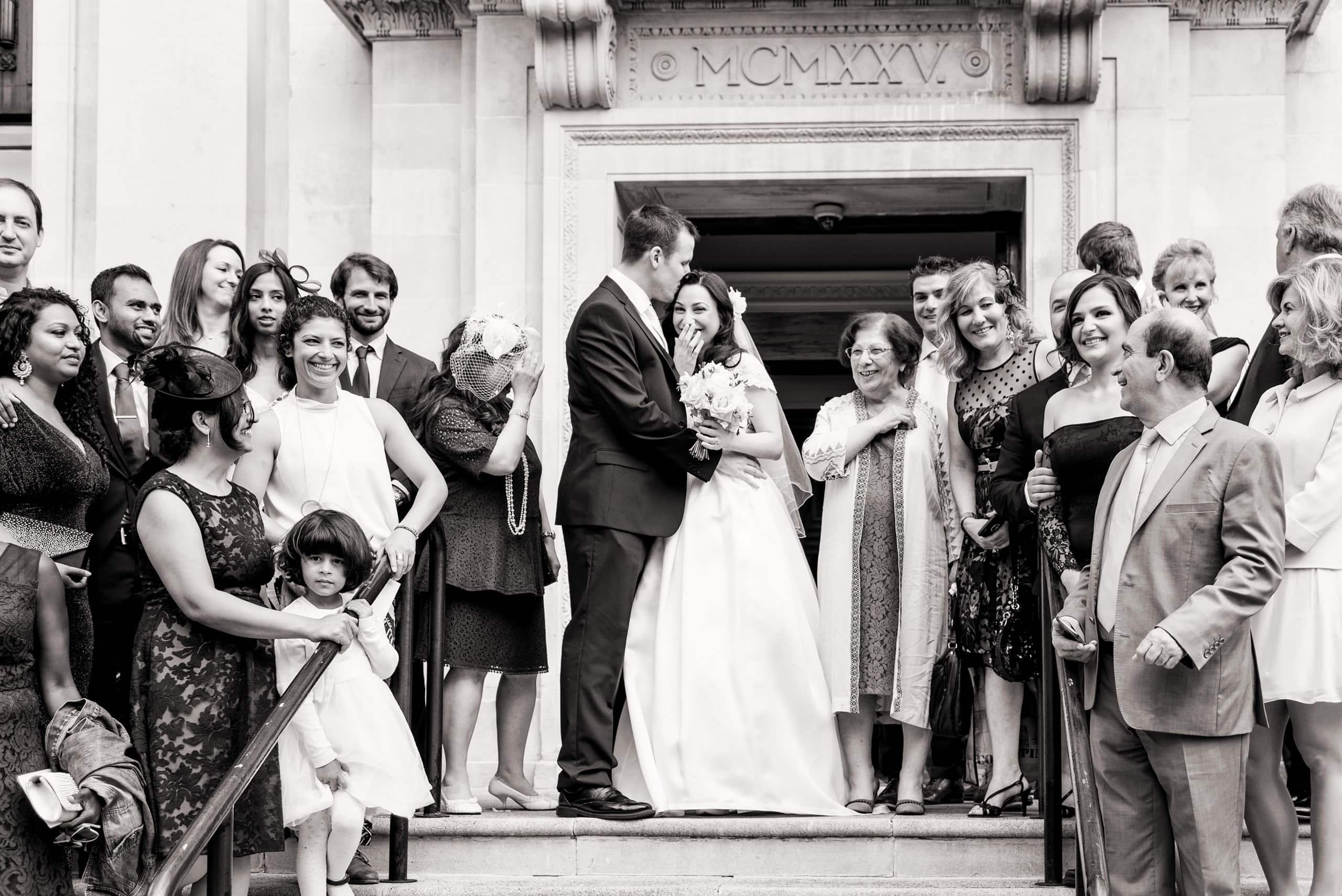 Bride and groom with family and friends on the front steps of Islington Town Hall after their ceremony