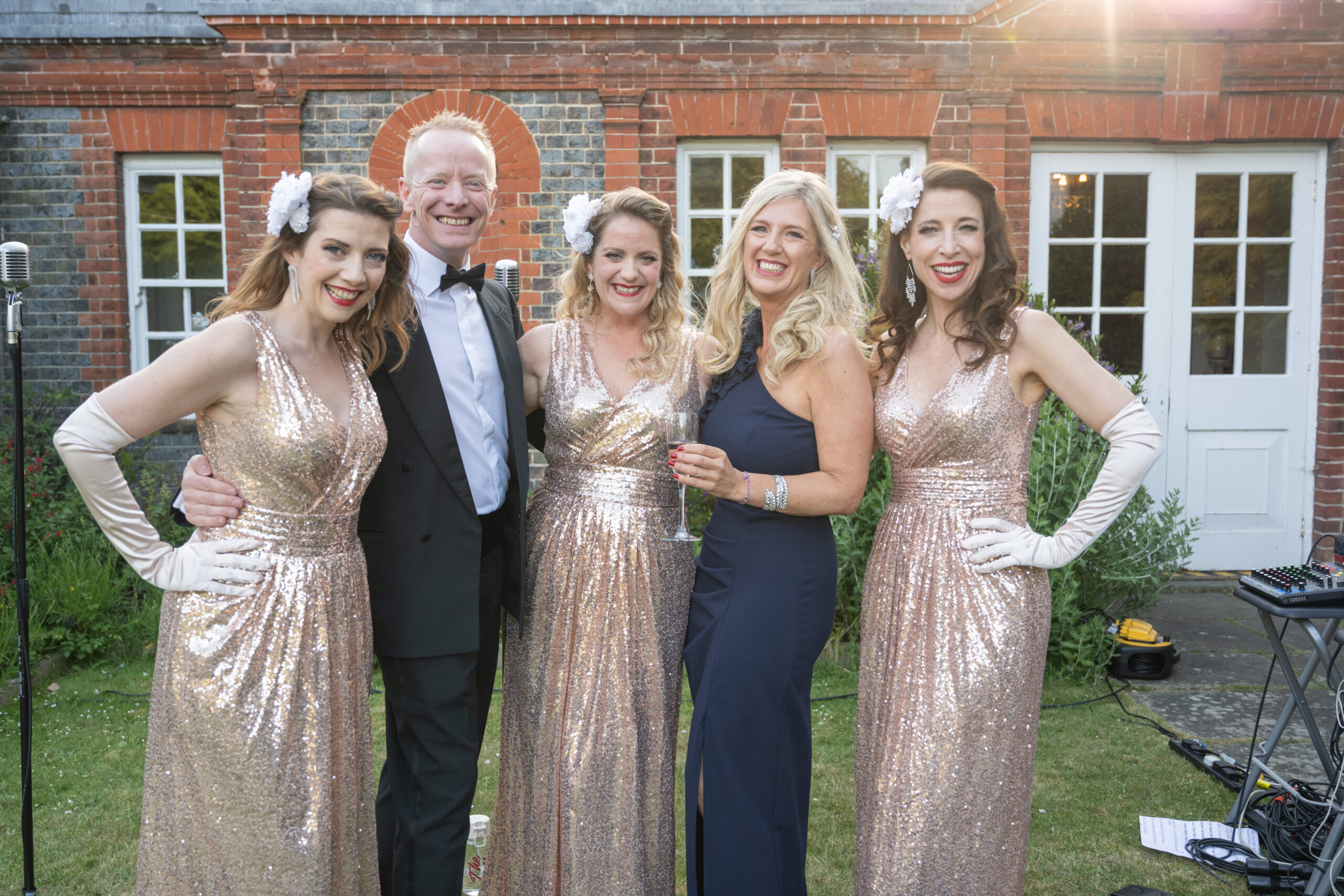 Guests with The Memphis Belles, a 1940s vocal trio, in the garden at Gildredge Manor, Eastbourne
