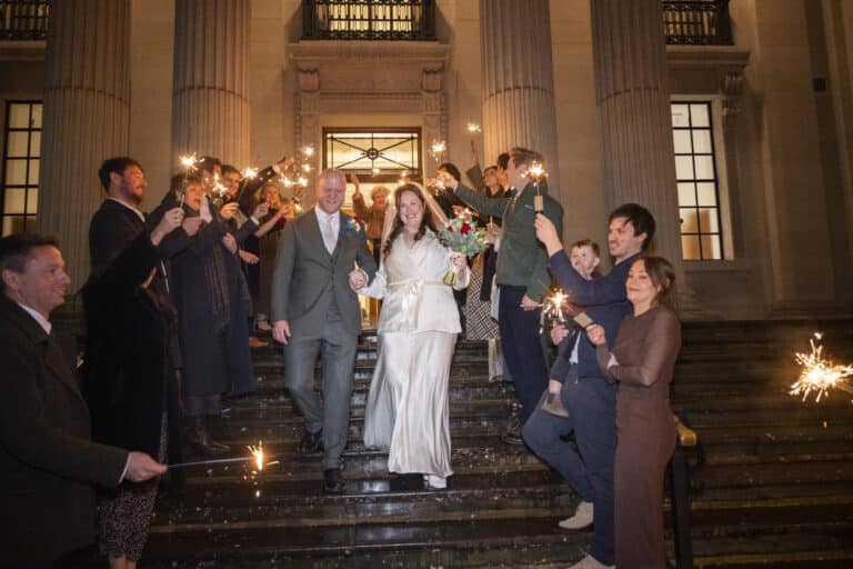 Nathalie and Rutger leaving Old Marylebone Town Hall down the steps through a sparkler send-off