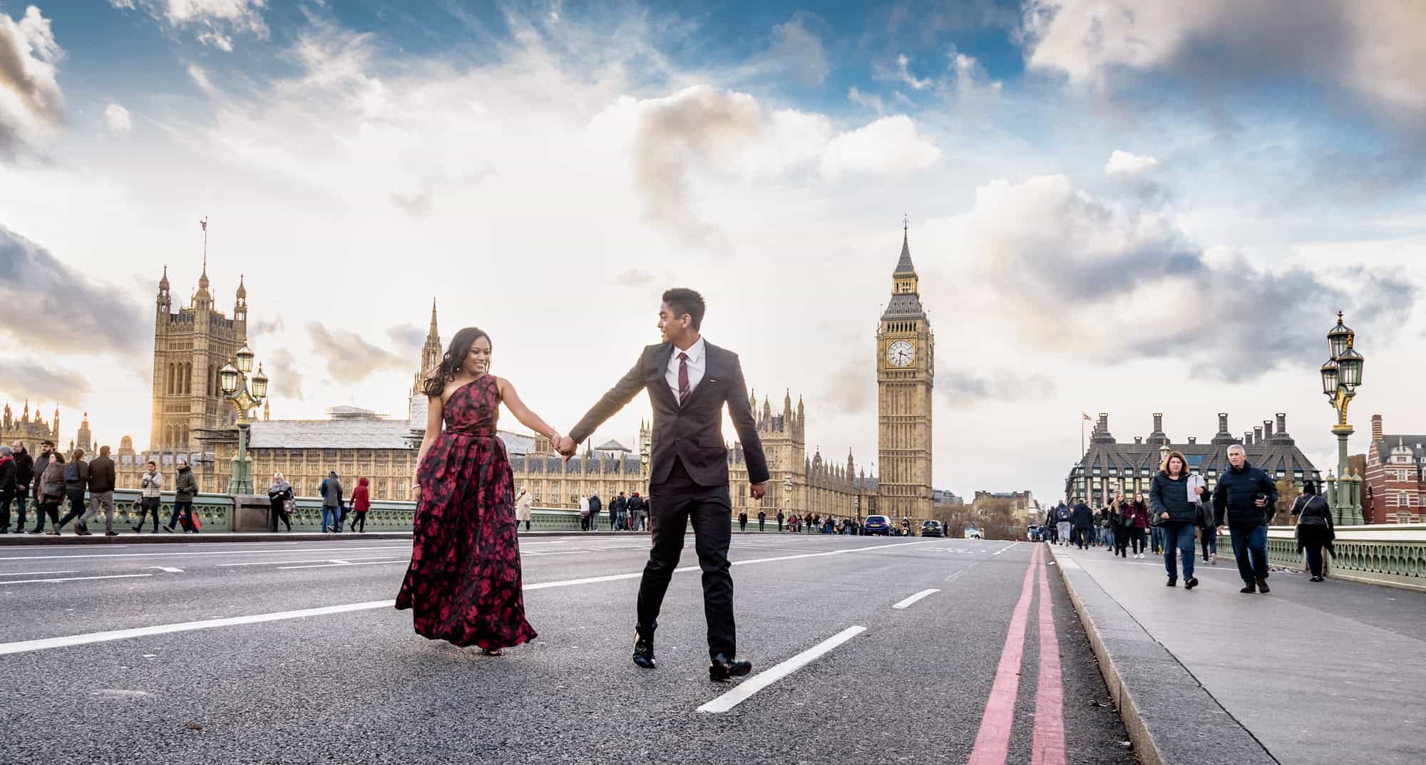 Couple holding hands on Westminster Bridge with Big Ben and the Houses of Parliament behind