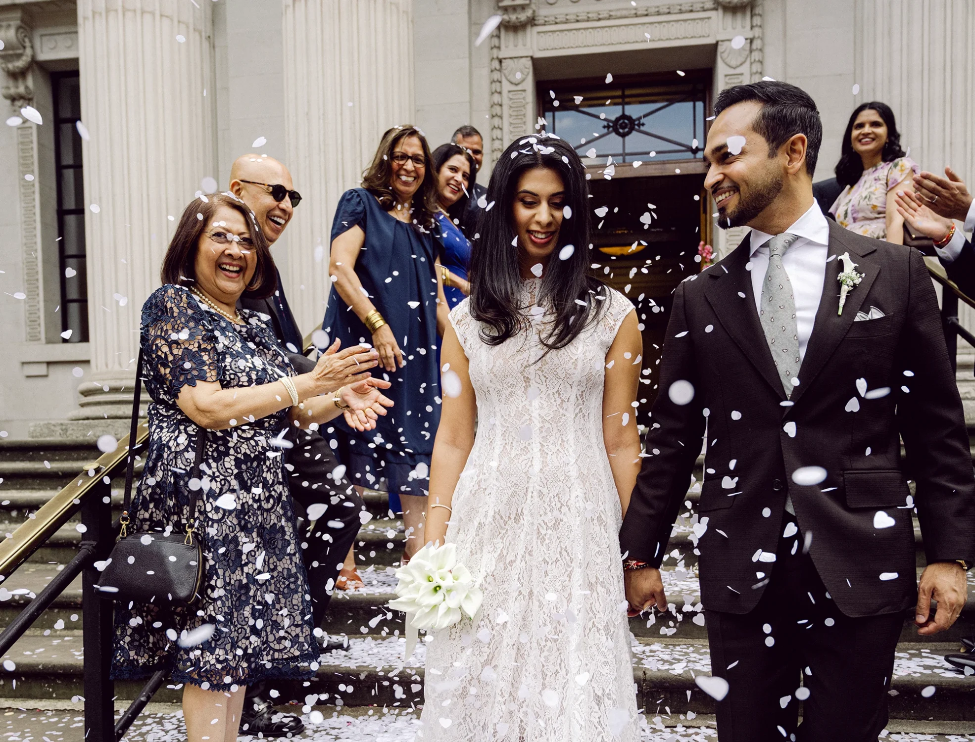 Confetti over the bride and groom on the steps of Old Marylebone Town Hall