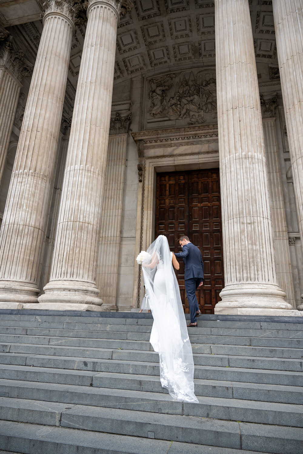 Bride walking up the steps of St Paul's Cathedral