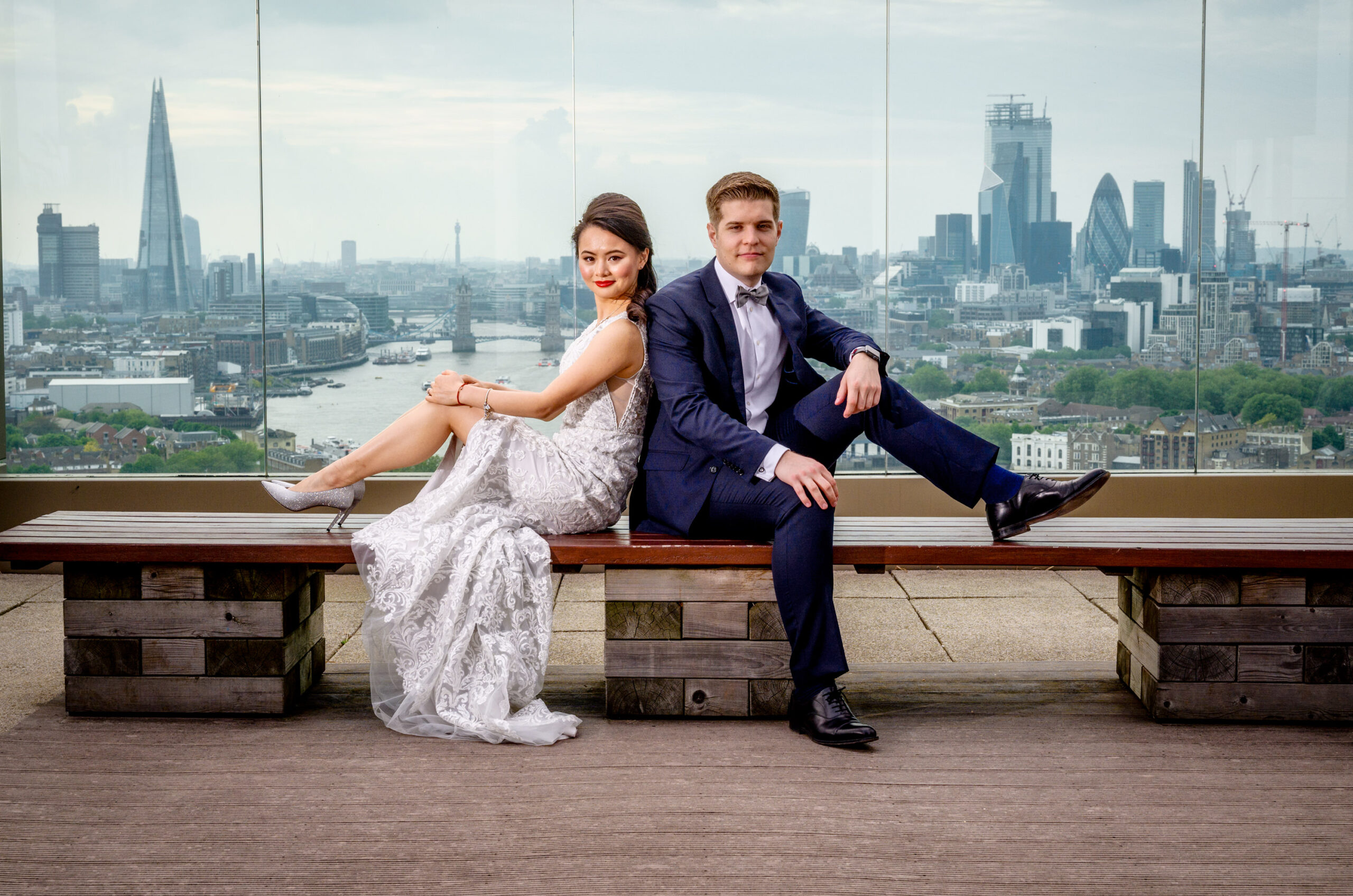Couple photographed on a rooftop with the London skyline behind them