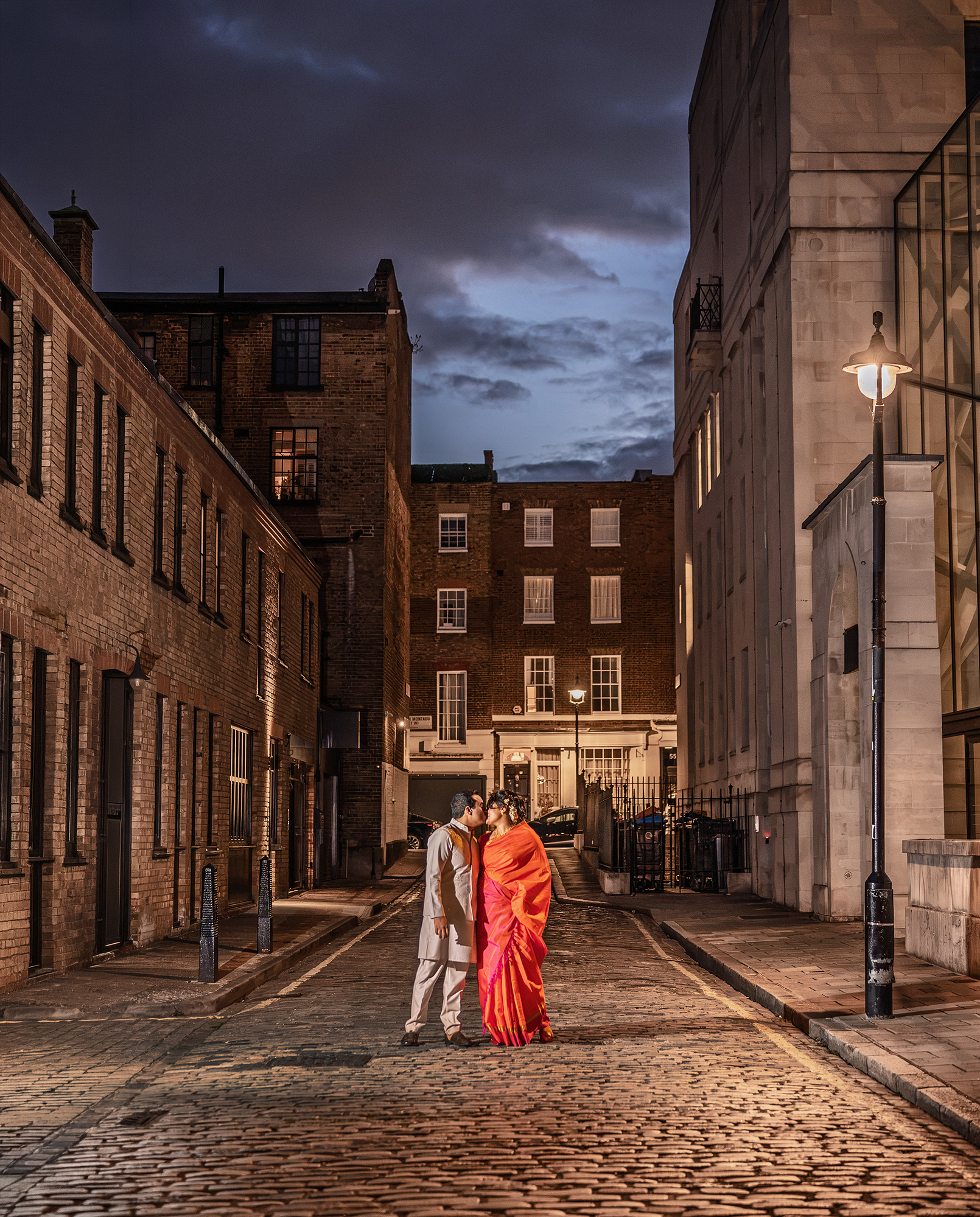 Bride and groom on a cobbled mews at dusk after their Old Marylebone Town Hall evening wedding