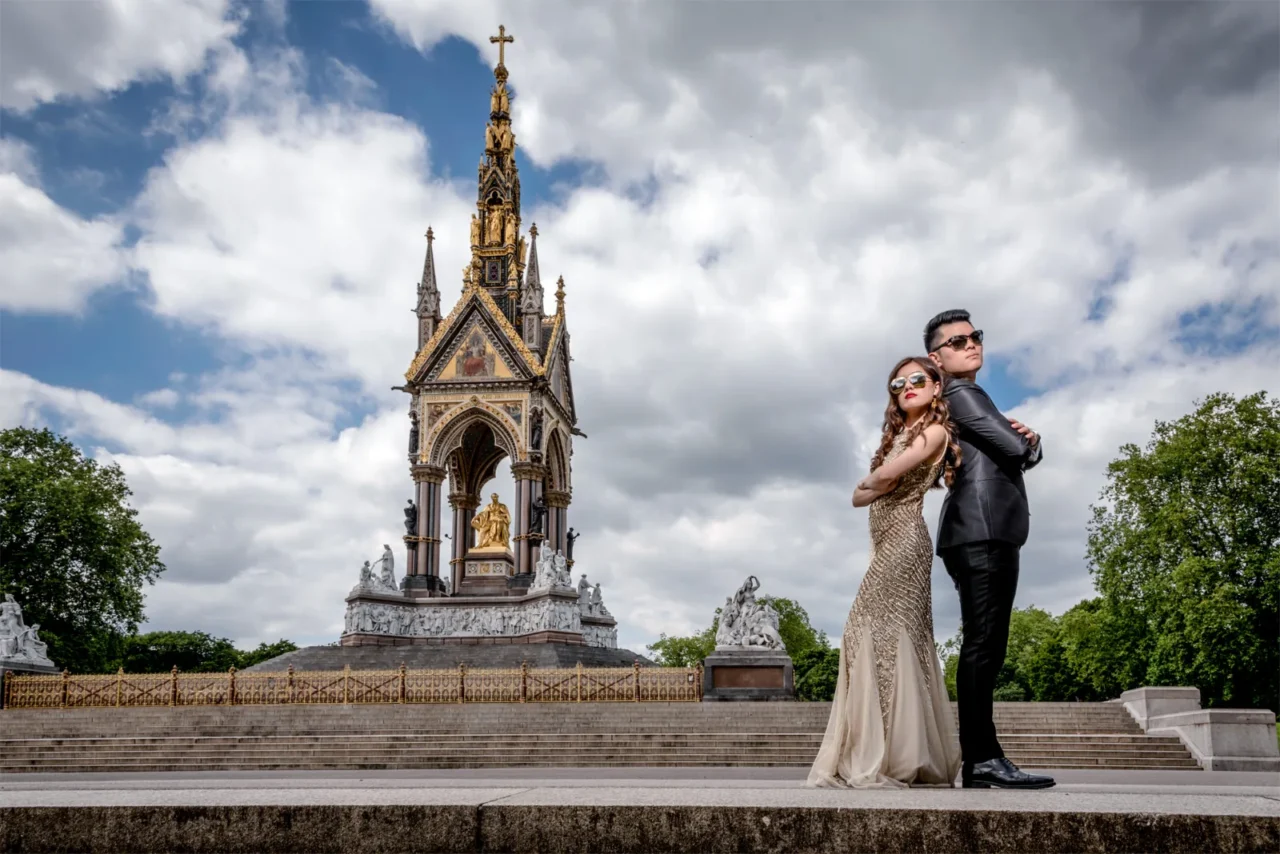 Couple in sunglasses standing back to back at the Albert Memorial, Kensington Gardens