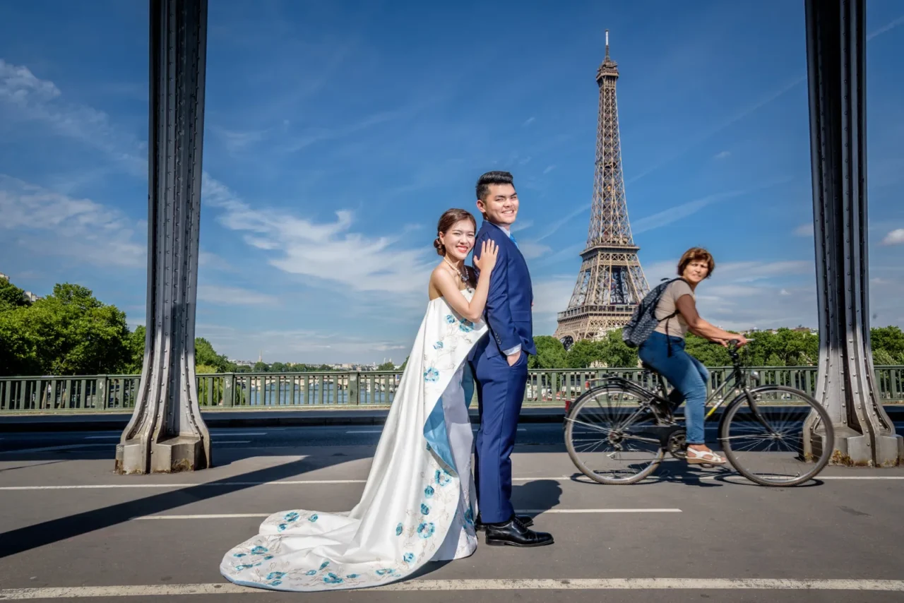 Couple on Pont de Bir-Hakeim with the Eiffel Tower behind and a cyclist passing, Paris pre wedding