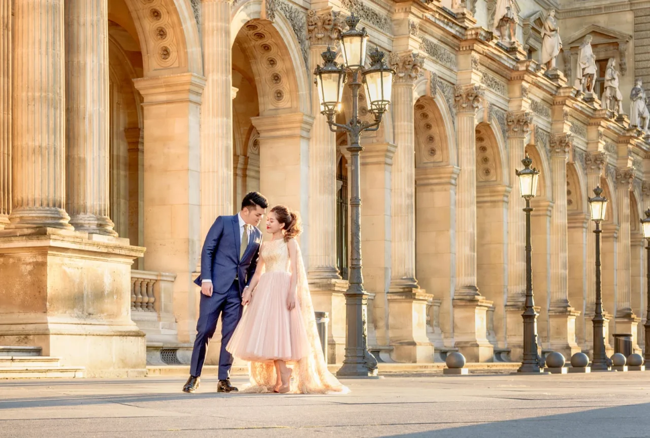 Couple kissing under the lamps along the Louvre colonnade, Paris pre wedding photography