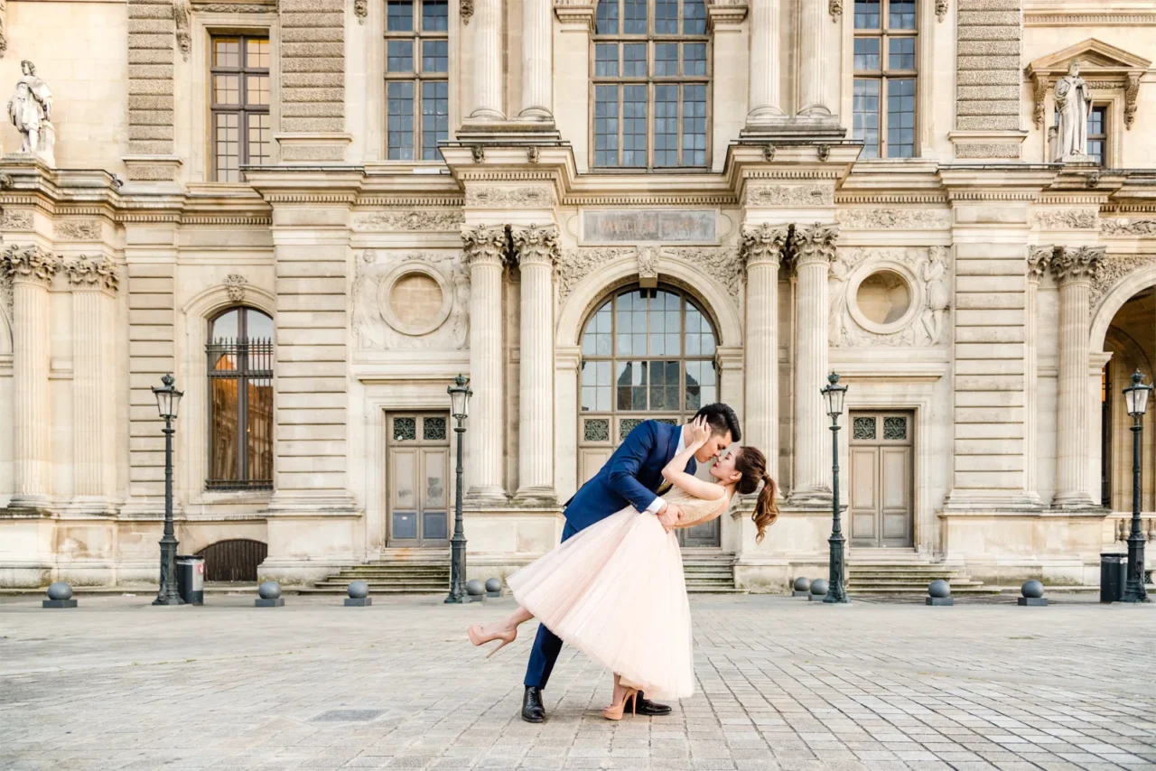 Groom dipping the bride in the Louvre courtyard, romantic Paris pre wedding photo