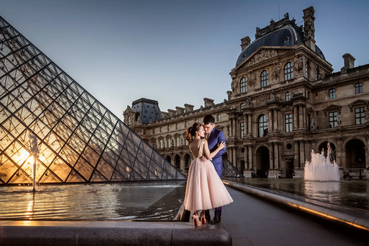 Cambodian couple kissing beside the Louvre pyramid fountains, Paris pre wedding photography