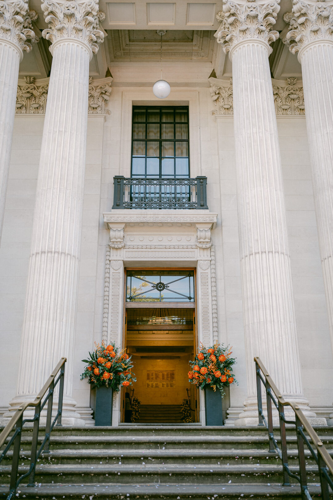 The entrance to Old Marylebone Town Hall with autumn flowers beside the doors