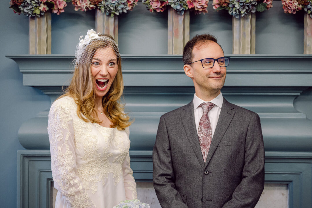 Patricia laughing beside Thomas on their wedding day at Old Marylebone Town Hall