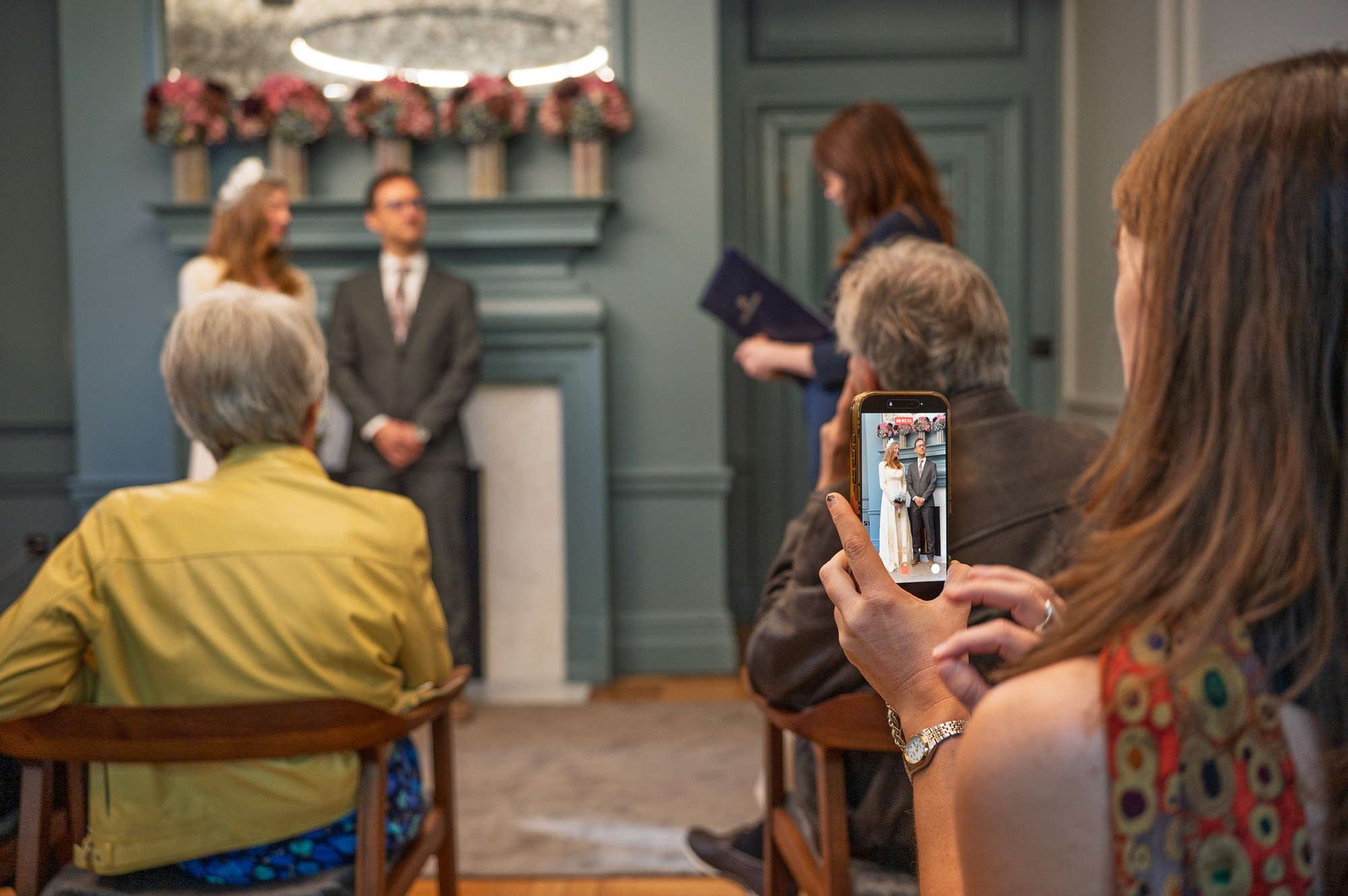 Family filming the ceremony on a phone at Old Marylebone Town Hall