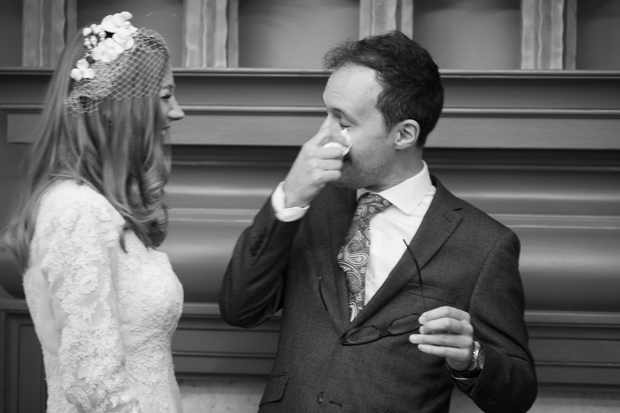 Groom wiping his eye during the ceremony at Old Marylebone Town Hall