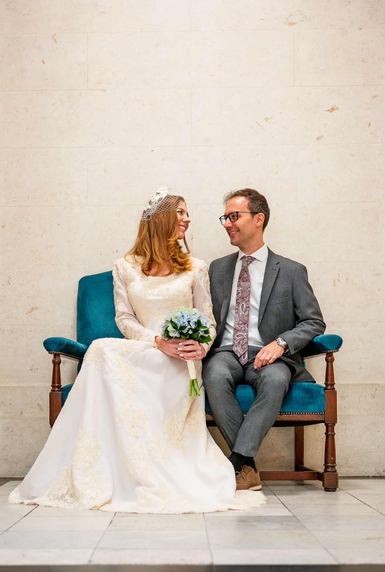 Bride and groom on a velvet chair in the Knightsbridge Room