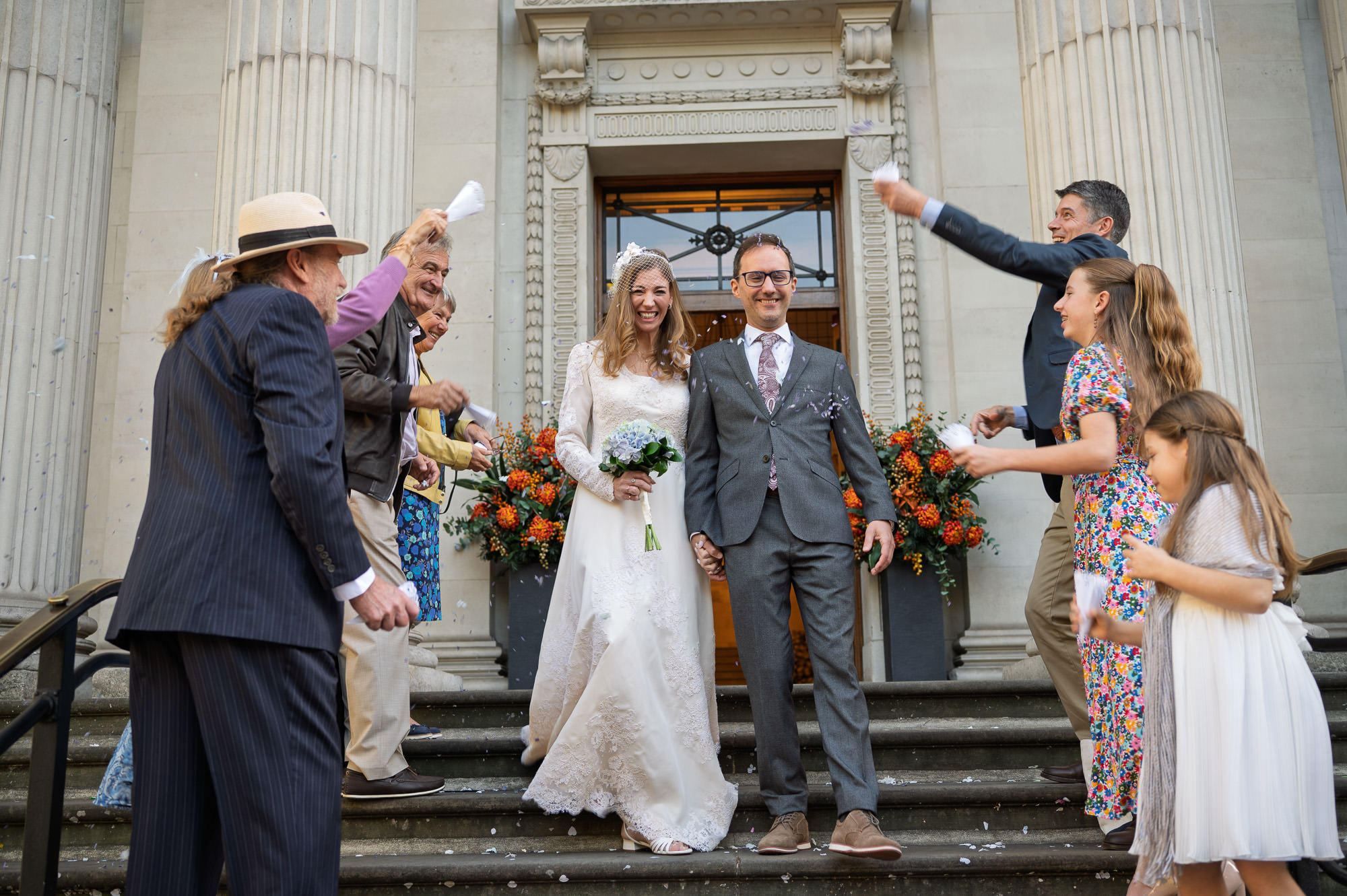 Patricia and Thomas in confetti on the steps of Old Marylebone Town Hall