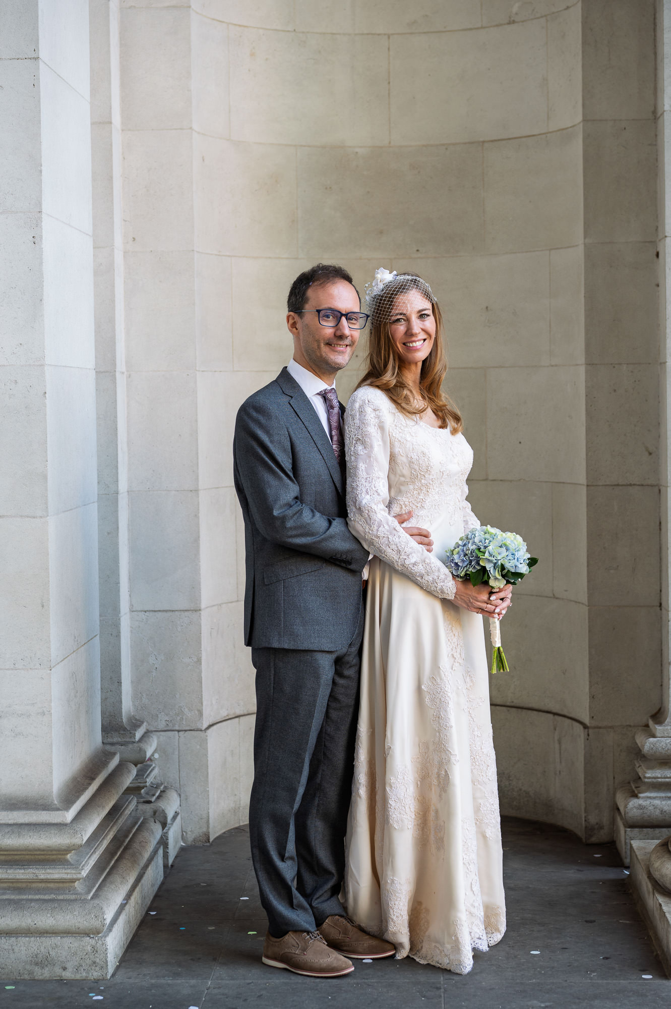 Bride and groom by the columns at Old Marylebone Town Hall on an autumn afternoon