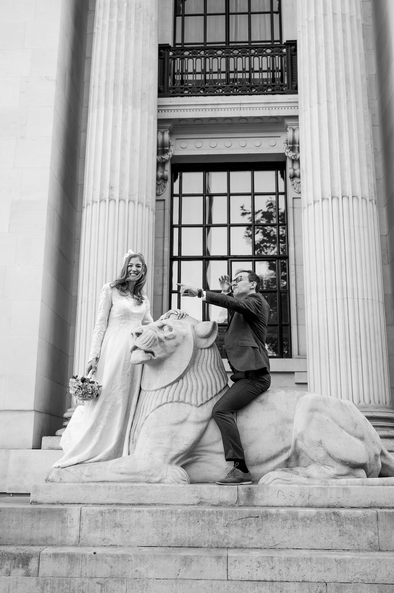 Black and white photo of the couple on the lion outside Old Marylebone Town Hall