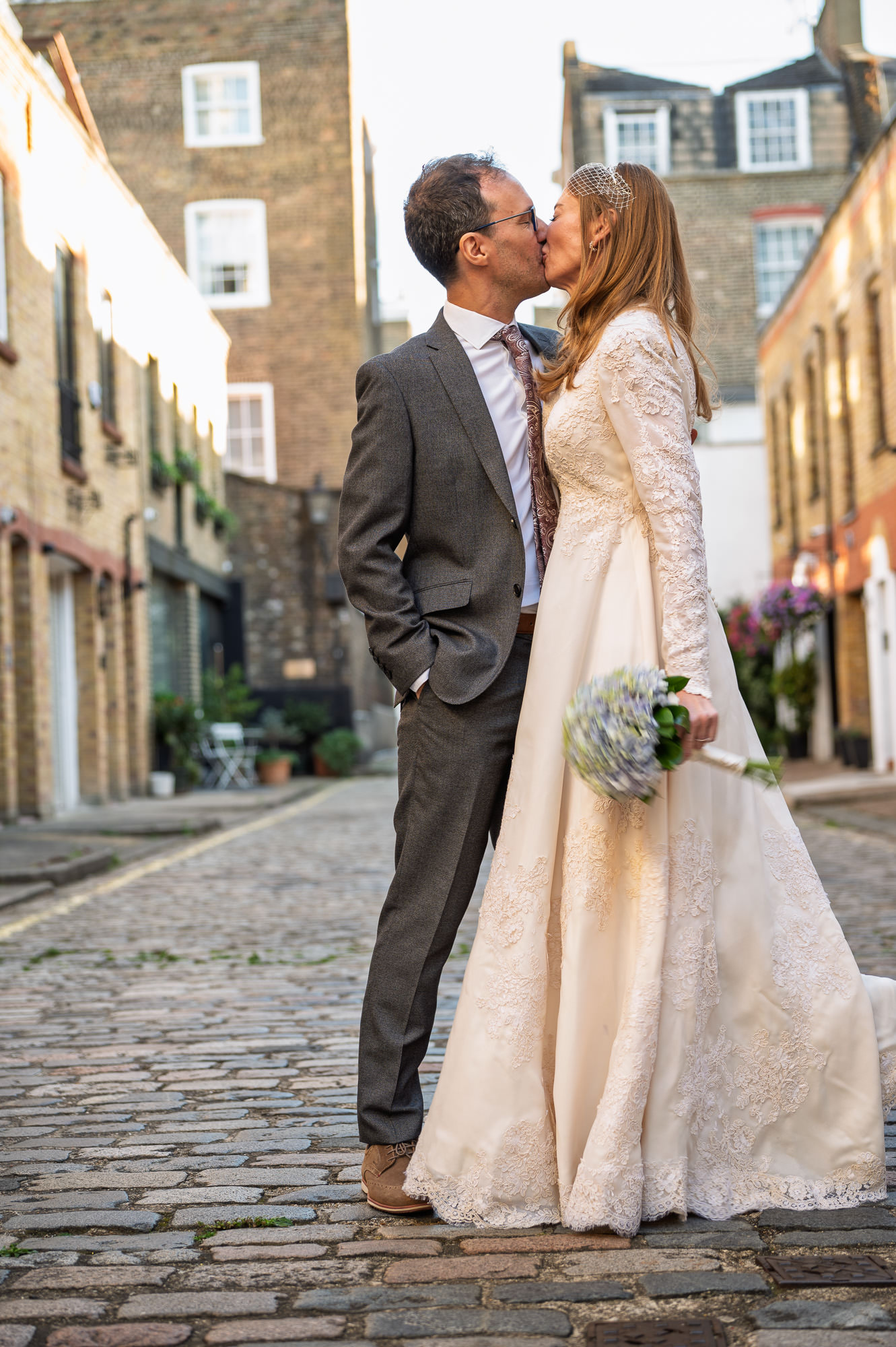 Bride and groom kissing on a cobbled mews near Old Marylebone Town Hall