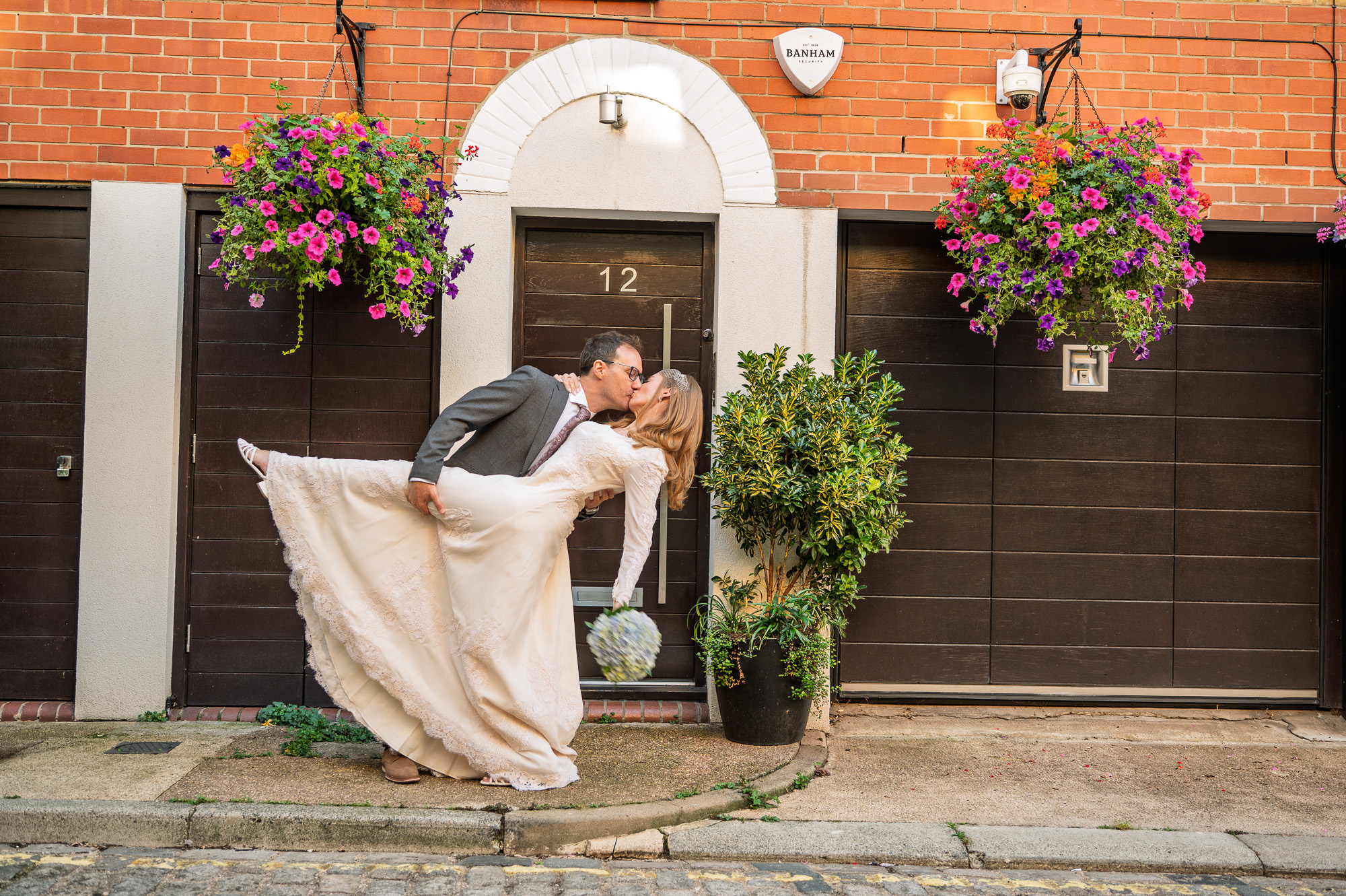 Groom dipping the bride for a kiss outside a mews house in Marylebone