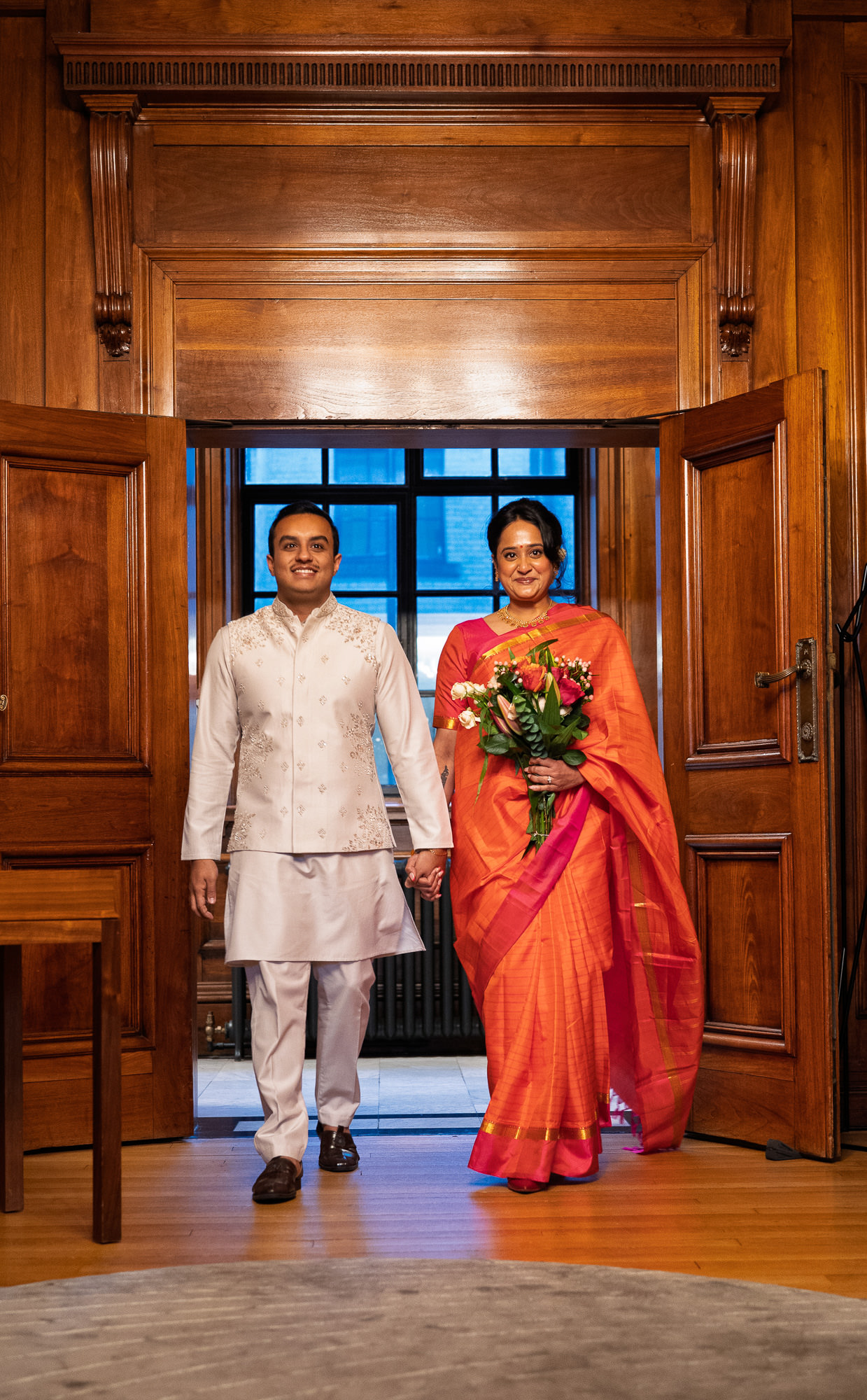 Bride and groom walking into the panelled Paddington Room together