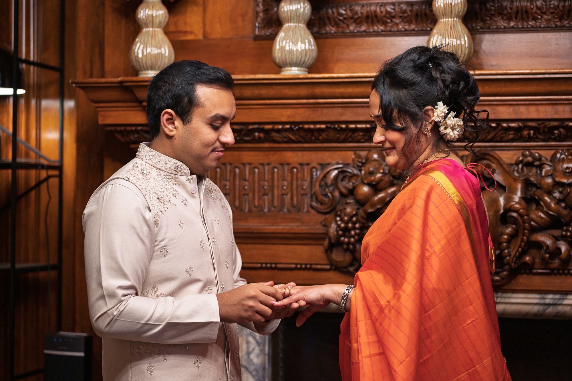 Groom placing the ring on the bride's finger at Old Marylebone Town Hall