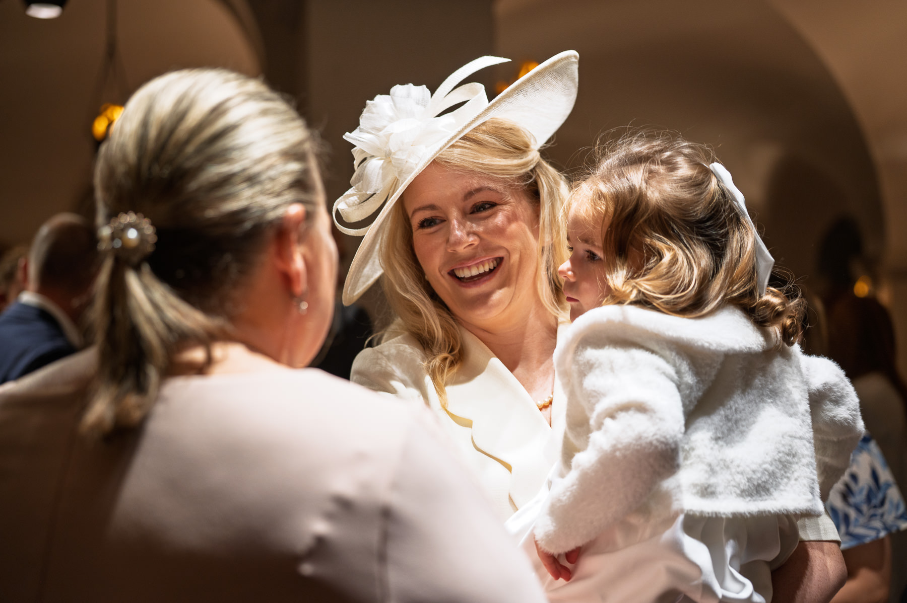 Mum laughing with her daughter in her arms before the christening in the OBE Chapel