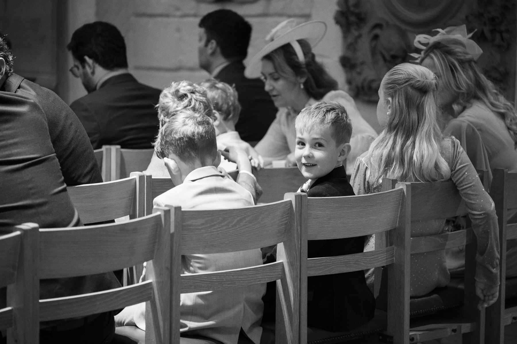 Black and white photo of children in the chairs of the OBE Chapel during the christening