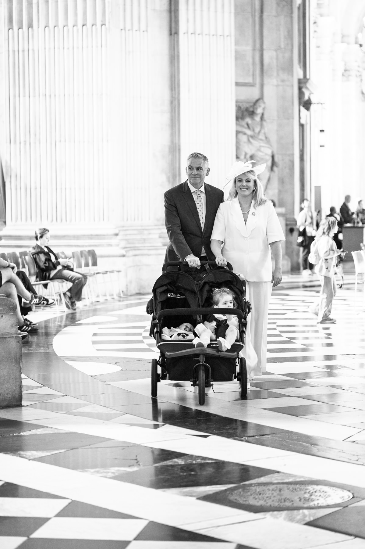 Black and white photo of the couple pushing the pram across the chequered floor of St Paul's Cathedral