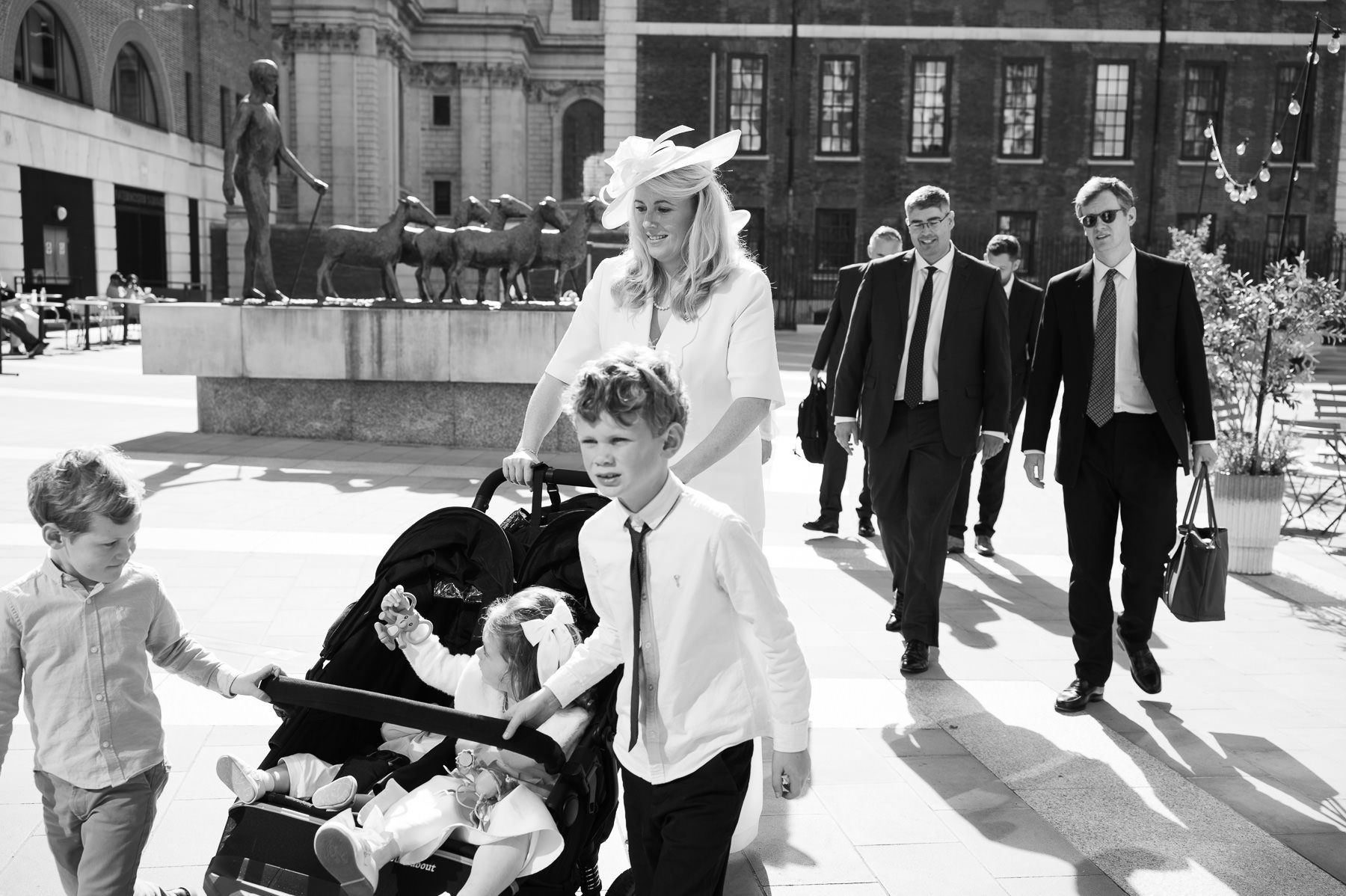 Black and white photo of the christening party crossing the square beside St Paul's Cathedral
