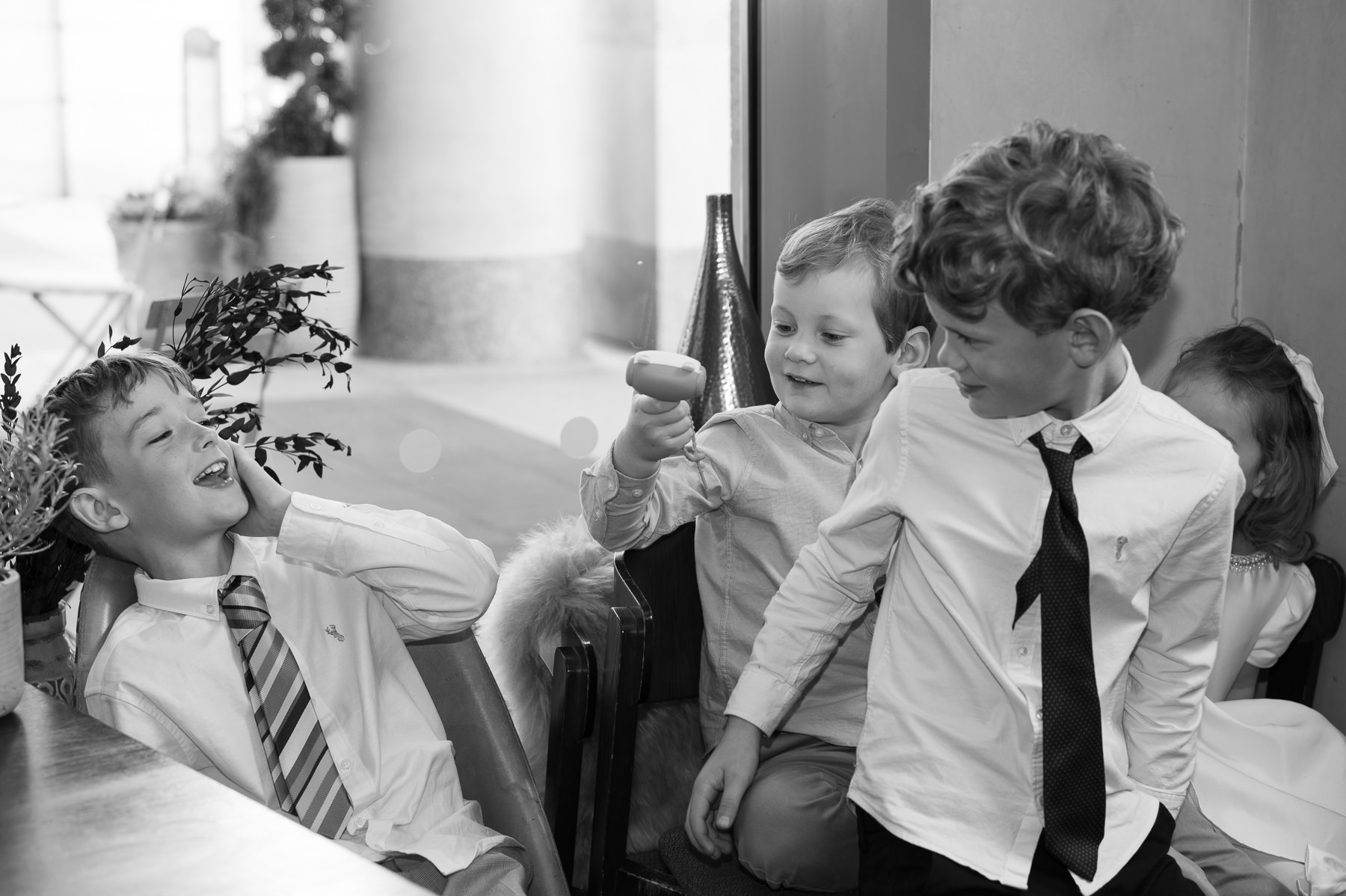 Black and white photo of children laughing at the table at Happenstance after the christening