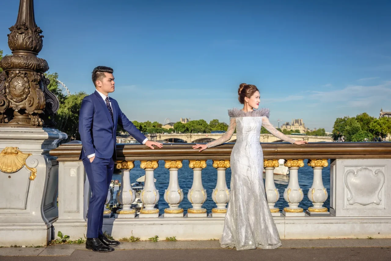 Bride in a silver gown and groom on Pont Alexandre III over the Seine, Paris