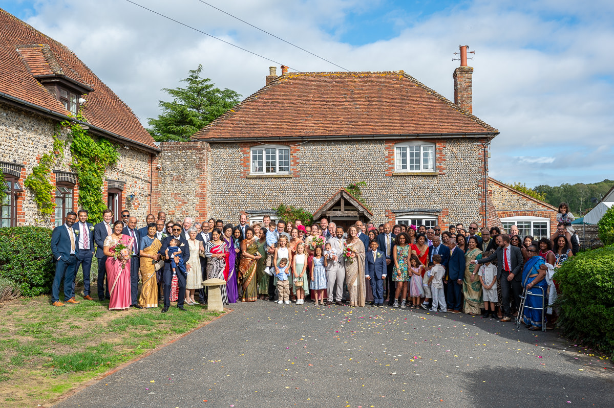 The full wedding group photographed outside the farmhouse at Selden Barns