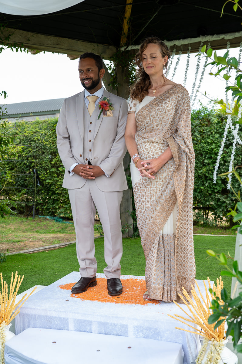 The bride and groom standing on the Poruwa during their Sri Lankan ceremony at Selden Barns