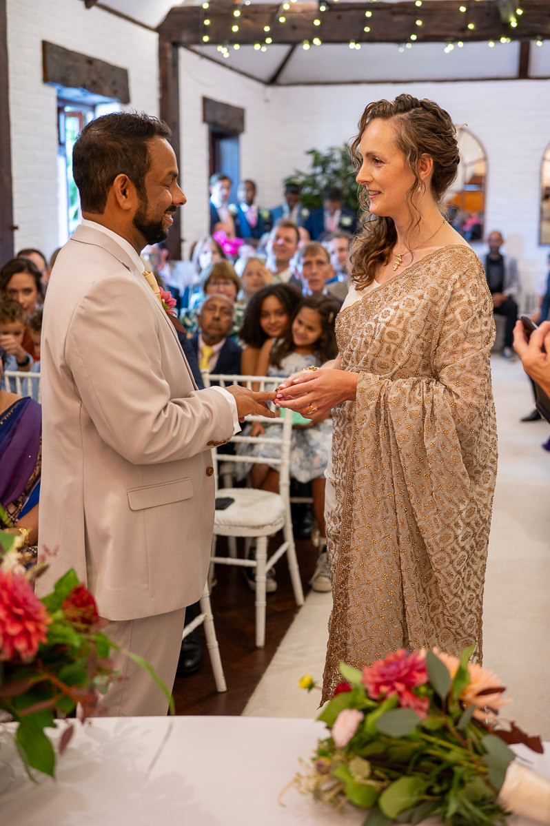 Exchanging rings during the civil ceremony in the ceremony barn at Selden Barns