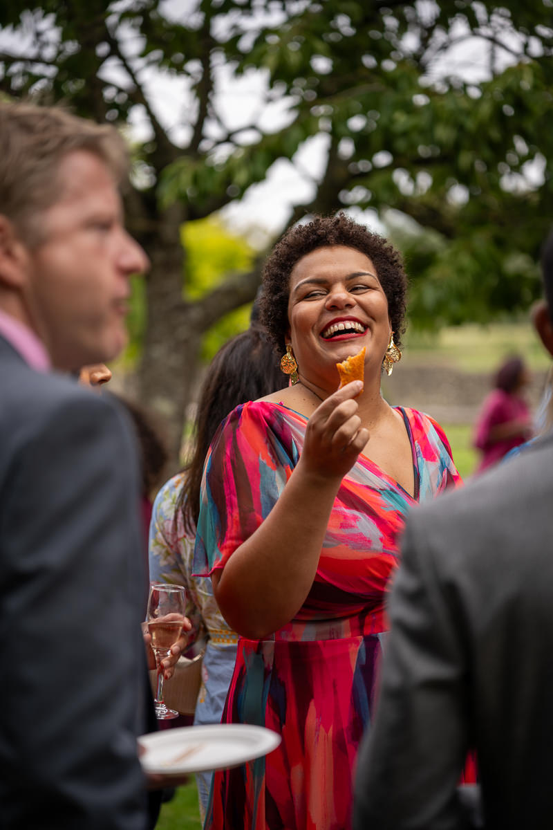 A guest laughing during drinks after the ceremony