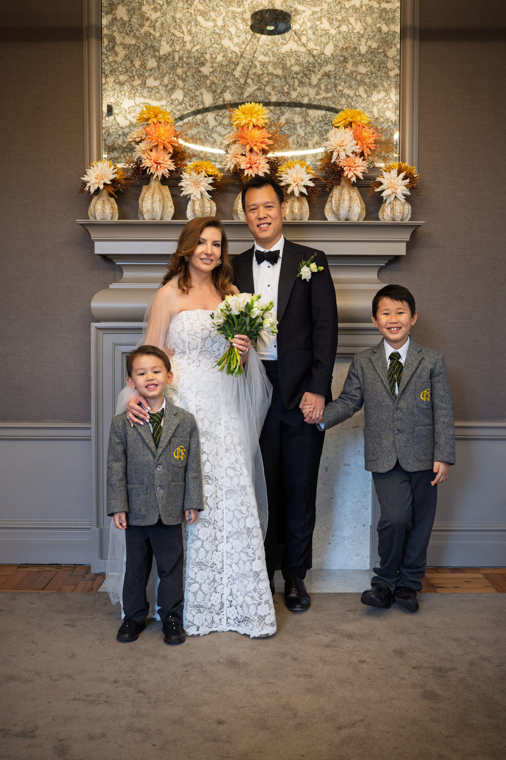 Nicoleta and Alistair with their two boys in front of the fireplace in the Pimlico Room, Old Marylebone Town Hall