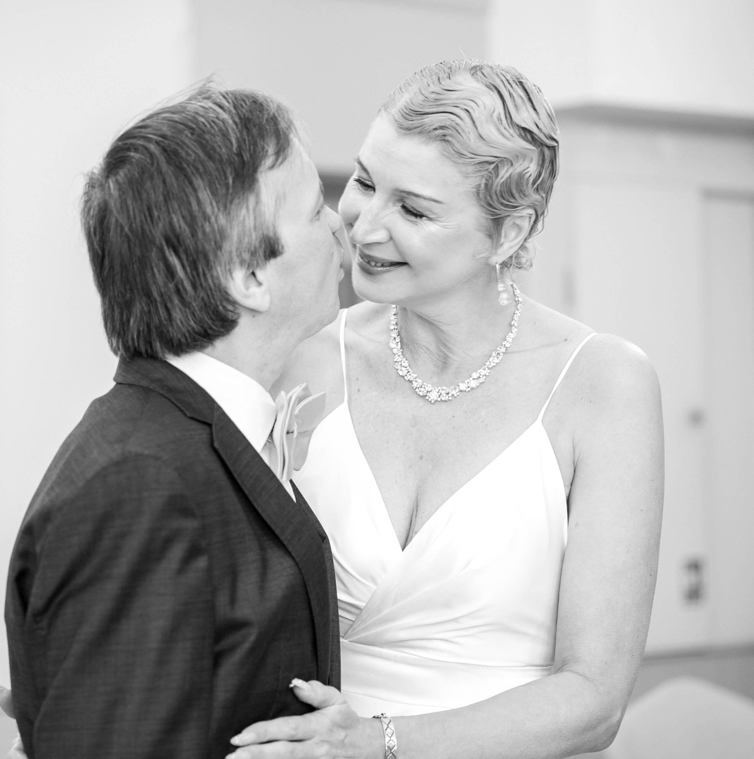 Black and white photo of Alexei and Nataliia cheek to cheek after their wedding ceremony in Ealing