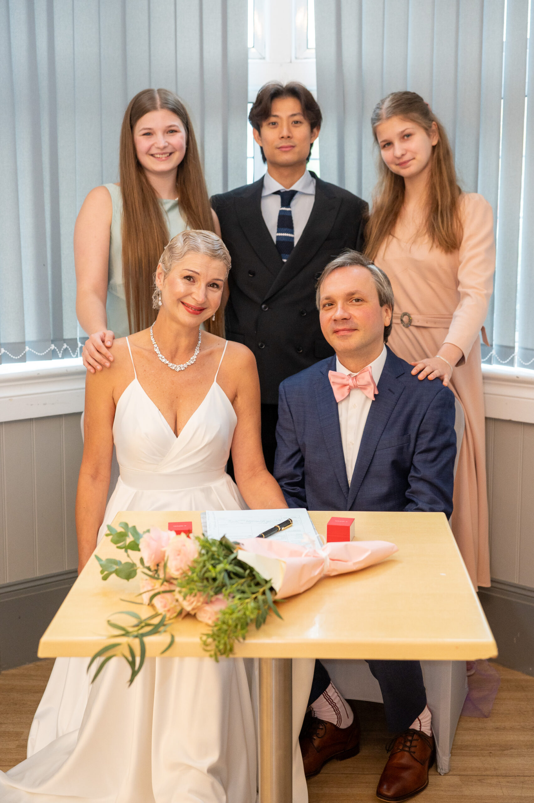 Alexei and Nataliia at the signing table with her two daughters and a guest standing behind them in Ealing
