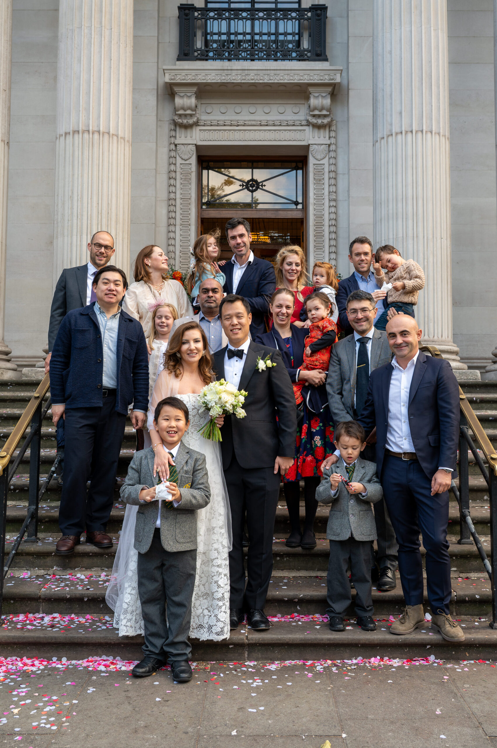 Group photo of all the wedding guests on the front steps of Old Marylebone Town Hall