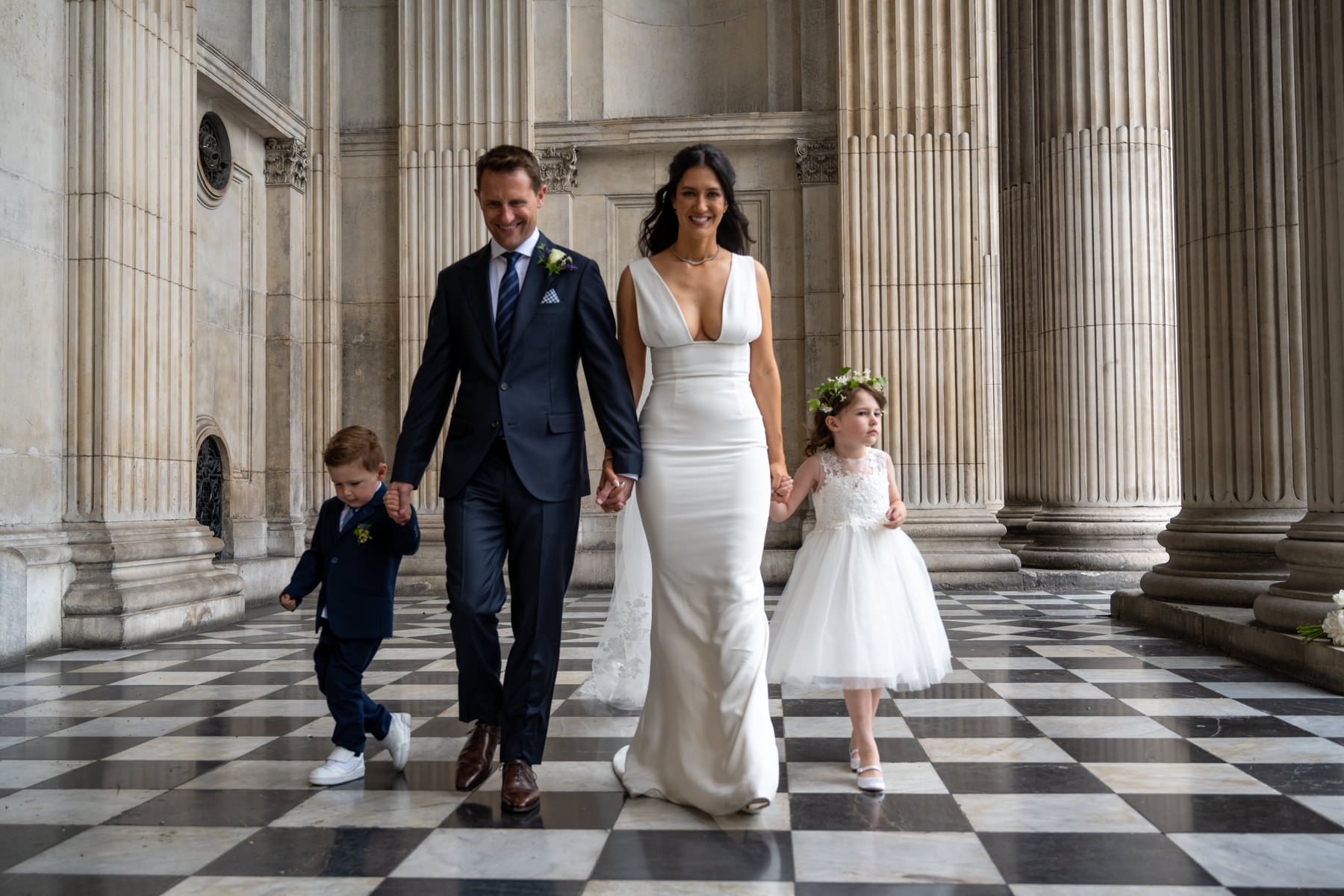 Sam and Matt walking with their children across the chequered floor of St Paul's Cathedral