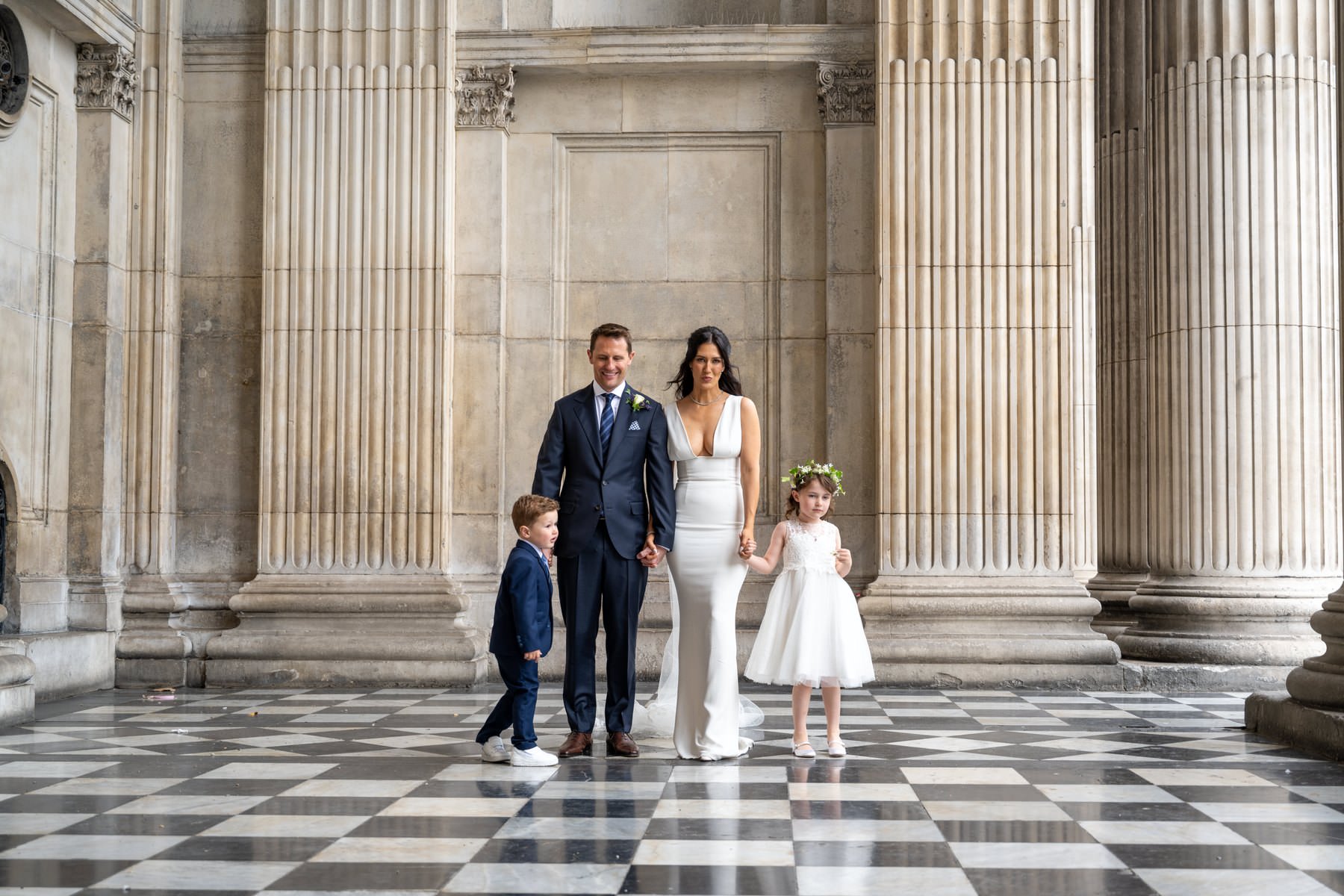 Sam and Matt walking across the chequered portico at St Paul's Cathedral with their son and daughter