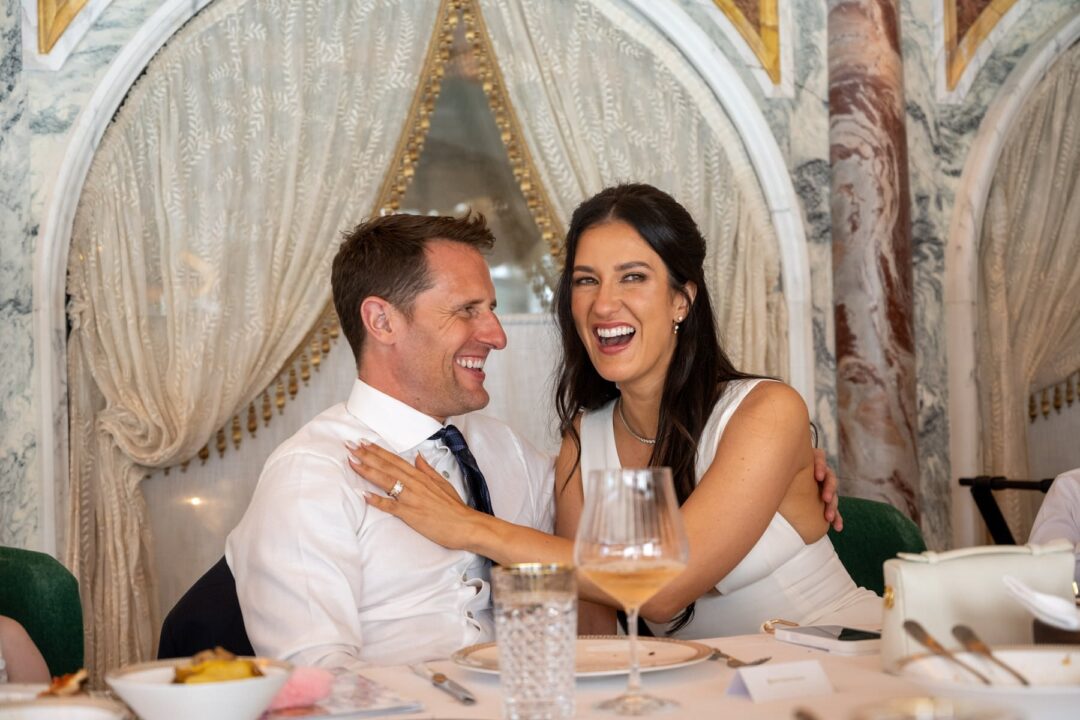 Bride and groom laughing together at the table during their wedding dinner in a private dining room in Mayfair